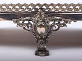 a silver plate with a design on it on a table