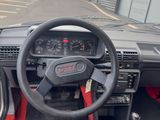 a dashboard and steering wheel of a car in a parking lot
