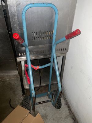 un diable bleu posé à côté d'un carton