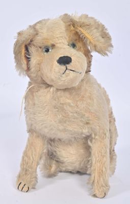 un chien en peluche assis sur une surface blanche