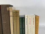 several books are lined up in a row on a white surface