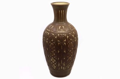 un vase brun posé sur une surface blanche
