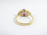 a close up of a gold ring with a pink stone