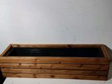 une jardinière en bois avec des doublures noires à l'intérieur