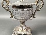 an ornate silver plated bowl with a lid on a stand