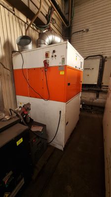 une machine orange et blanche qui se trouve dans un bâtiment