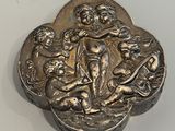 une vieille boîte en argent posée sur une table blanche