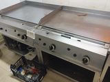 a large stainless steel grill in a kitchen with a basket on the floor