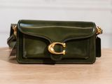 a green purse sitting on top of a wooden table