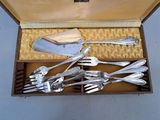 a lot of silverware in a box on the floor