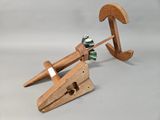 a wooden clamp with a green flower on top of it