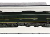une locomotive verte et jaune dans une boîte blanche posée sur une surface blanche