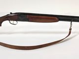 un vieux fusil avec une crosse en bois et un étui transparent