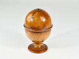 a small wooden ball on a stand on a white surface