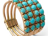 un gros plan sur un bracelet en or orné de pierres de turquoise