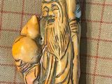 une figurine représentant un homme tenant un chat sur une table