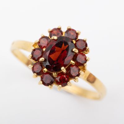 gros plan d'une bague en or avec une pierre rouge
