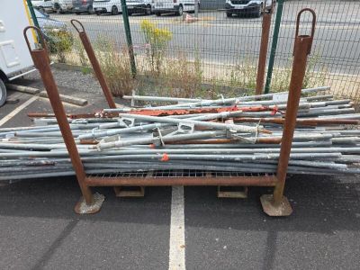 un tas de tuyaux métalliques posés sur un parking