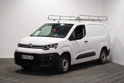 la camionnette blanche est garée dans une pièce au sol en damier
