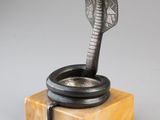a sculpture of a cobra on a marble base