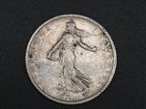 an old silver coin with a woman on it on a black surface