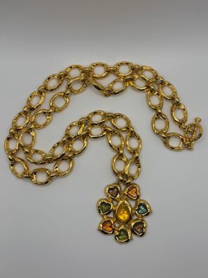 a gold chain necklace with multi colored stones on it