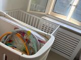 un lit de bébé dans une chambre avec une fenêtre et un radiateur