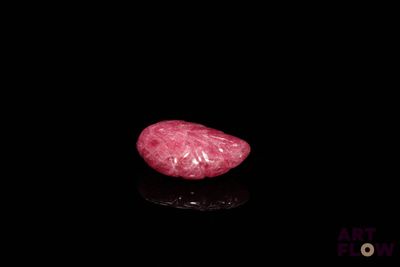 a close up of a pink diamond on a black surface