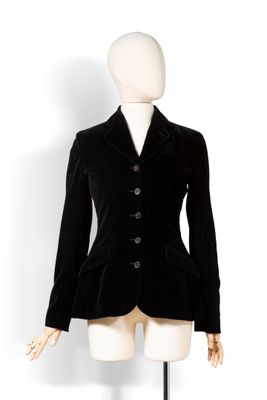 une image représentant un mannequin vêtu d'une veste noire sur un présentoir blanc