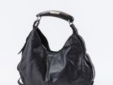 un sac en cuir noir muni d'une poignée métallique, sur fond blanc