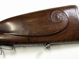 an old gun with a wooden case on a white surface