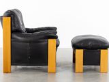 a black leather chair and ottoman on a concrete floor
