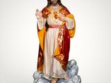 the statue of jesus is standing on a cloud with a crown on his head