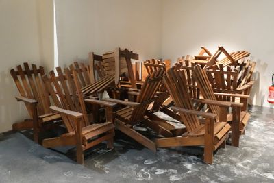 a pile of wooden chairs sitting in a room