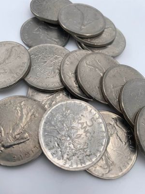 une pile de pièces d'argent sur une surface blanche