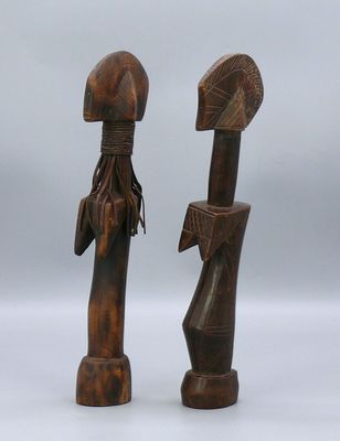 une paire de sculptures en bois représentant un homme et une femme tenant des parapluies