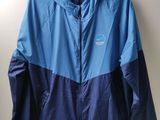 une veste bleue et noire accrochée au mur, à côté d'un cintre