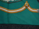 a green bag with a yellow and white ribbon on it