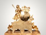 a gold statue of a woman and a globe on a stand