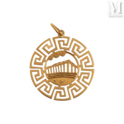 un gros plan d'un pendentif plaqué or orné d'un motif grec