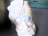 une petite statue représentant un homme, posée sur un bureau à côté d'une feuille de papier
