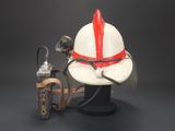 a fireman ' s helmet and a lighter next to it