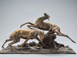 une sculpture en bronze représentant deux cerfs courant sur un rocher