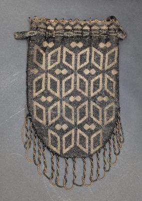 un sac gris et blanc orné de franges