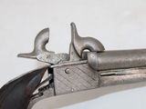 an old gun with a wooden handle on a white surface