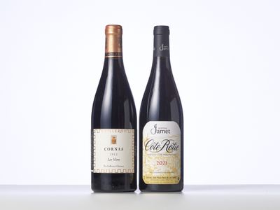 two bottles of wine sit side by side on a table