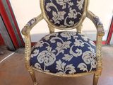 an old chair with a blue and gold upholstered seat
