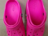 a pair of pink crocs are sitting on the floor