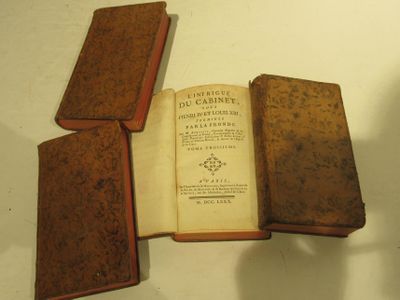 un vieux livre ouvert sur trois pages du même ouvrage