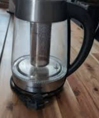 a coffee maker on a wooden table in a kitchen